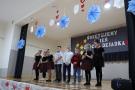 dzieci ustawione z brzegu sceny z mikrofonami