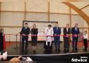 zebrani goście przecinają wstęgę na scenie
