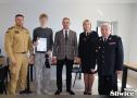 chłopak pozuje z dyplomem za udział