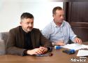zebrani na sali podpisują umowy
