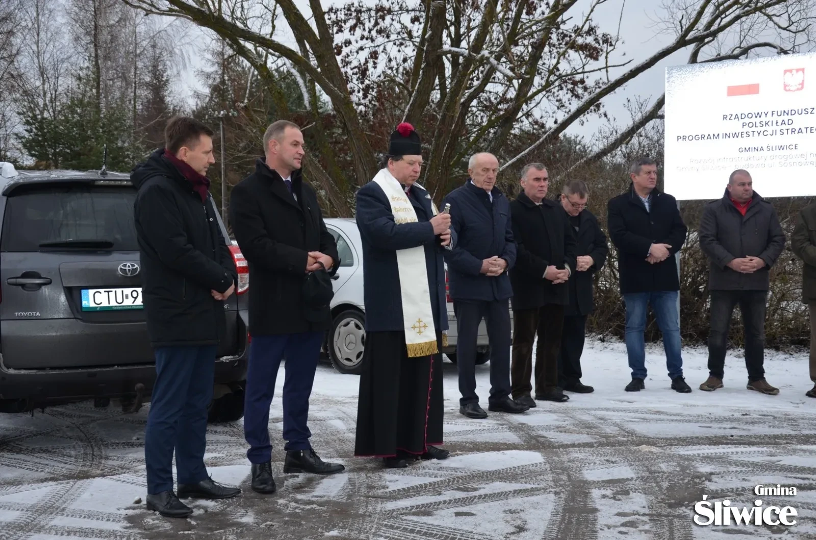 Wójt, proboszcz, minister, inni zgromadzeni na ulicy sosnowej