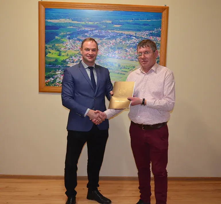 Dwóch Panów z umową podający sobie rękę 