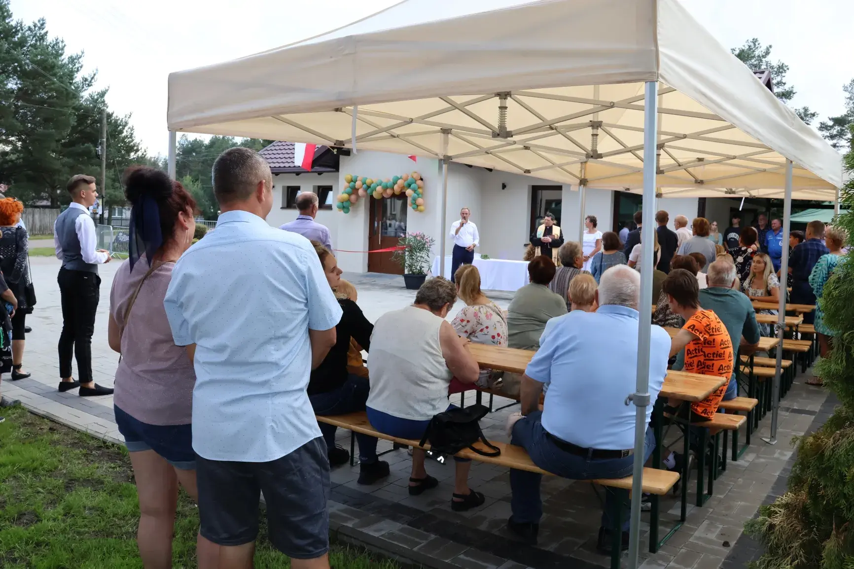 ludzie słuchający wypowiedzi wójta