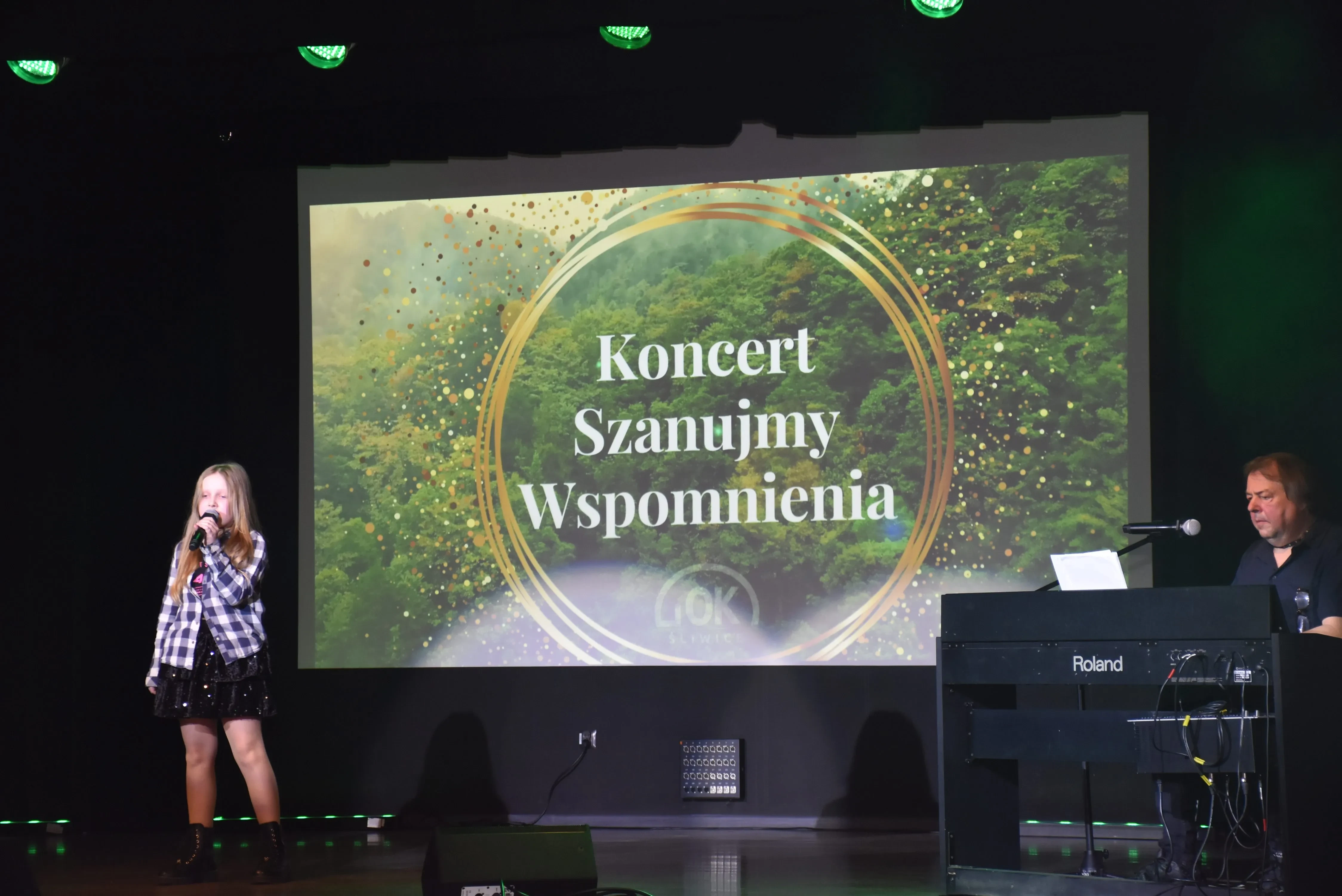 śpiewająca dziewczyna w sukience i artysta przy pianinie
