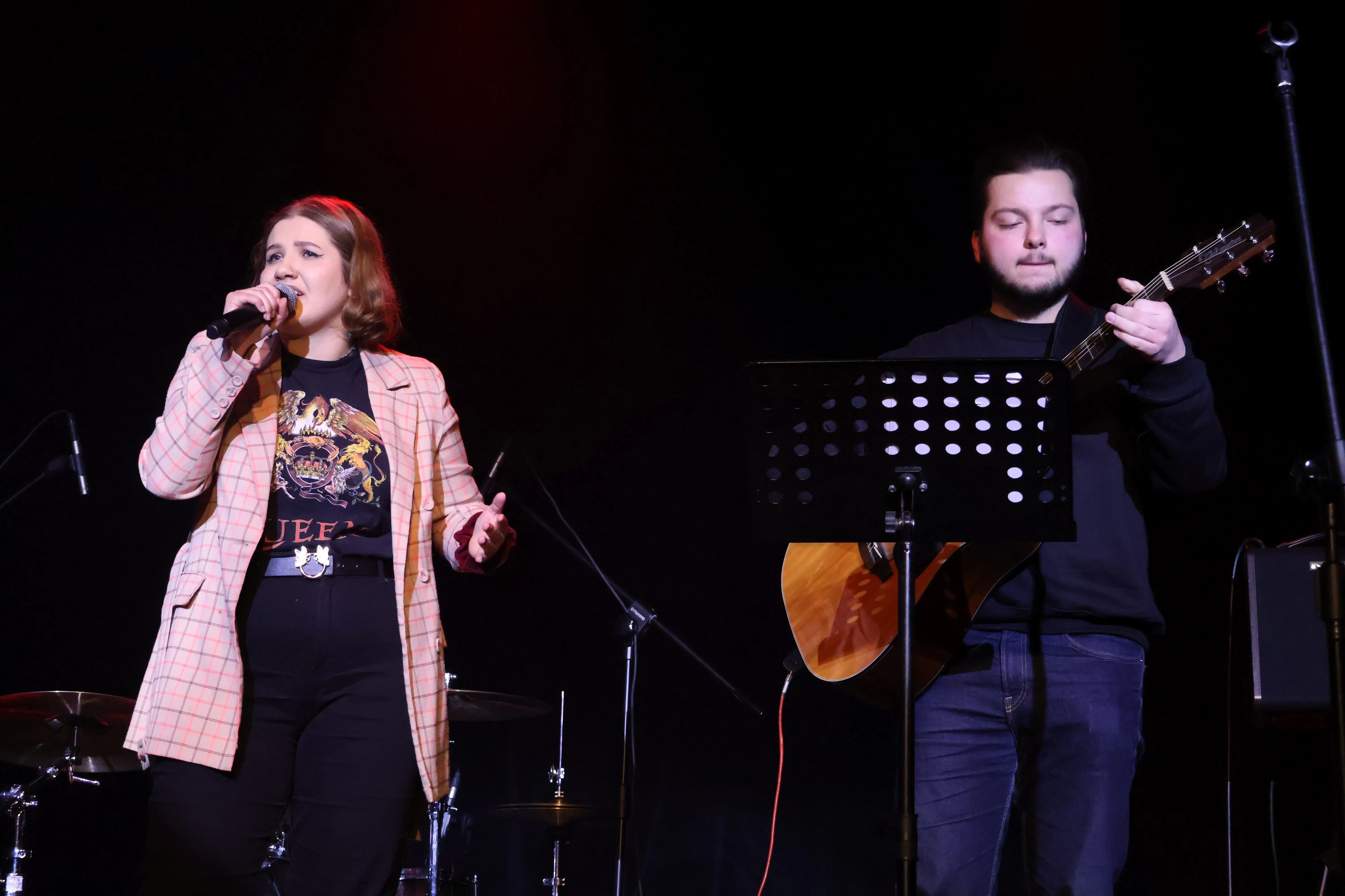 śpiewająca kobieta i mężczyzna z gitarą