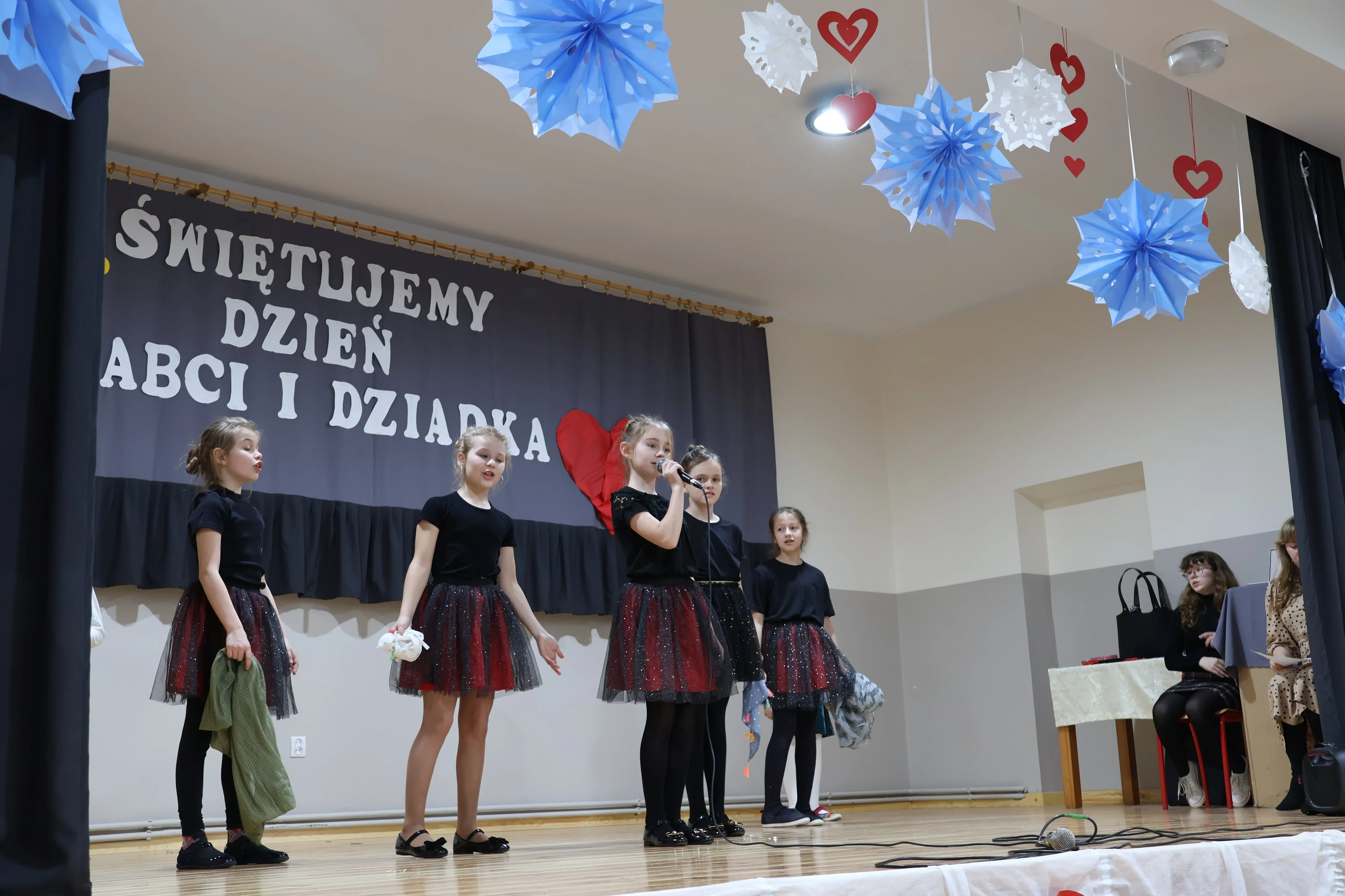 dzieci śpiewają na scenie i tańczą