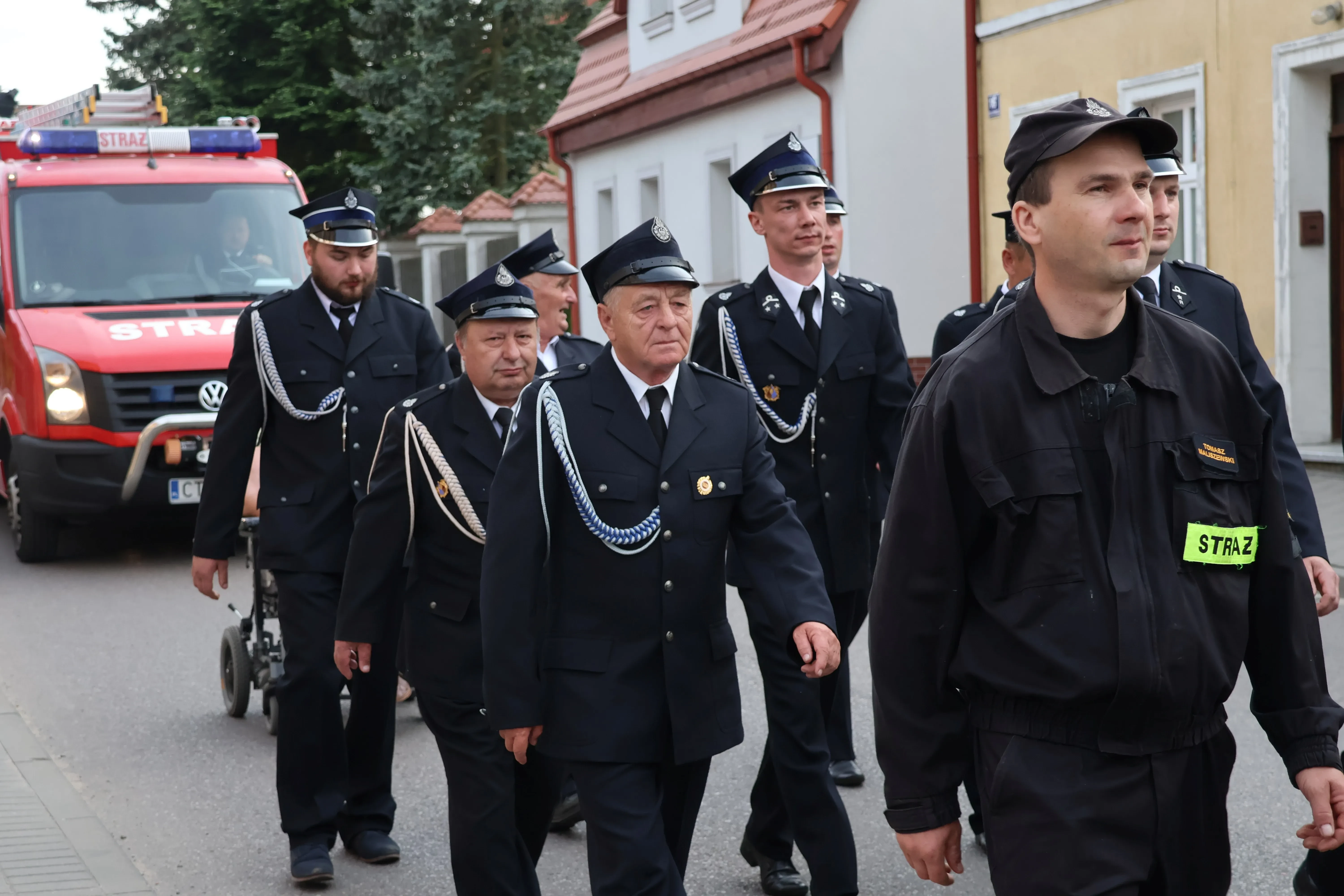 przemarsz strażaków za nimi wóz strażacki