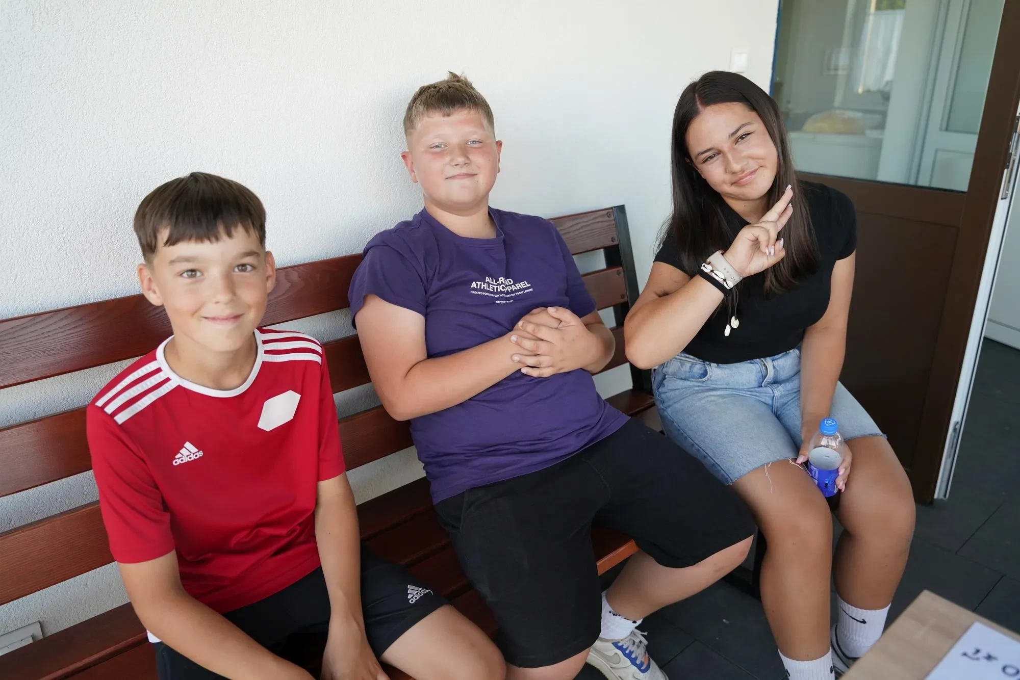 dwóch chłopaków i dziewczyna na ławce