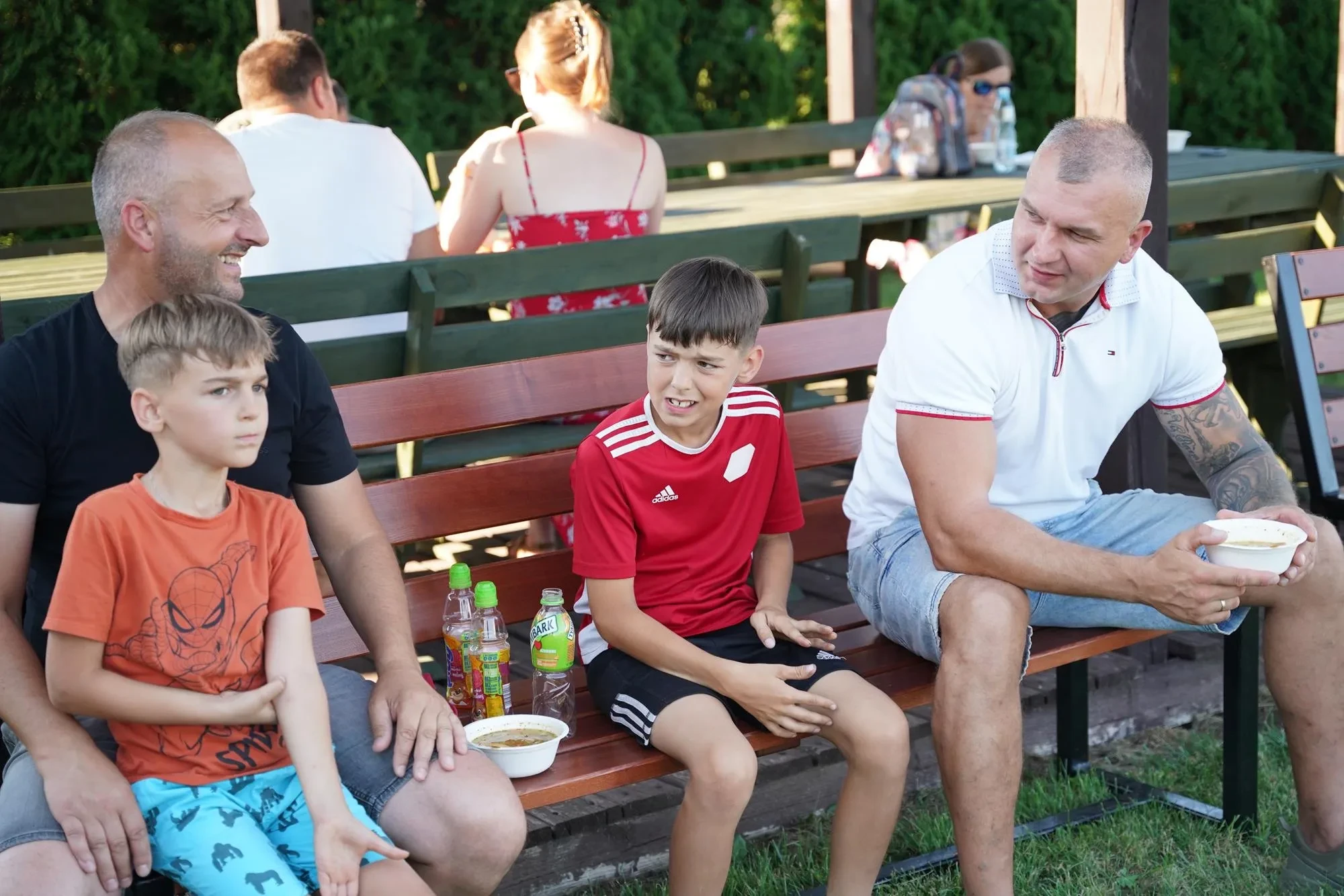 ludzie siedzą na ławce