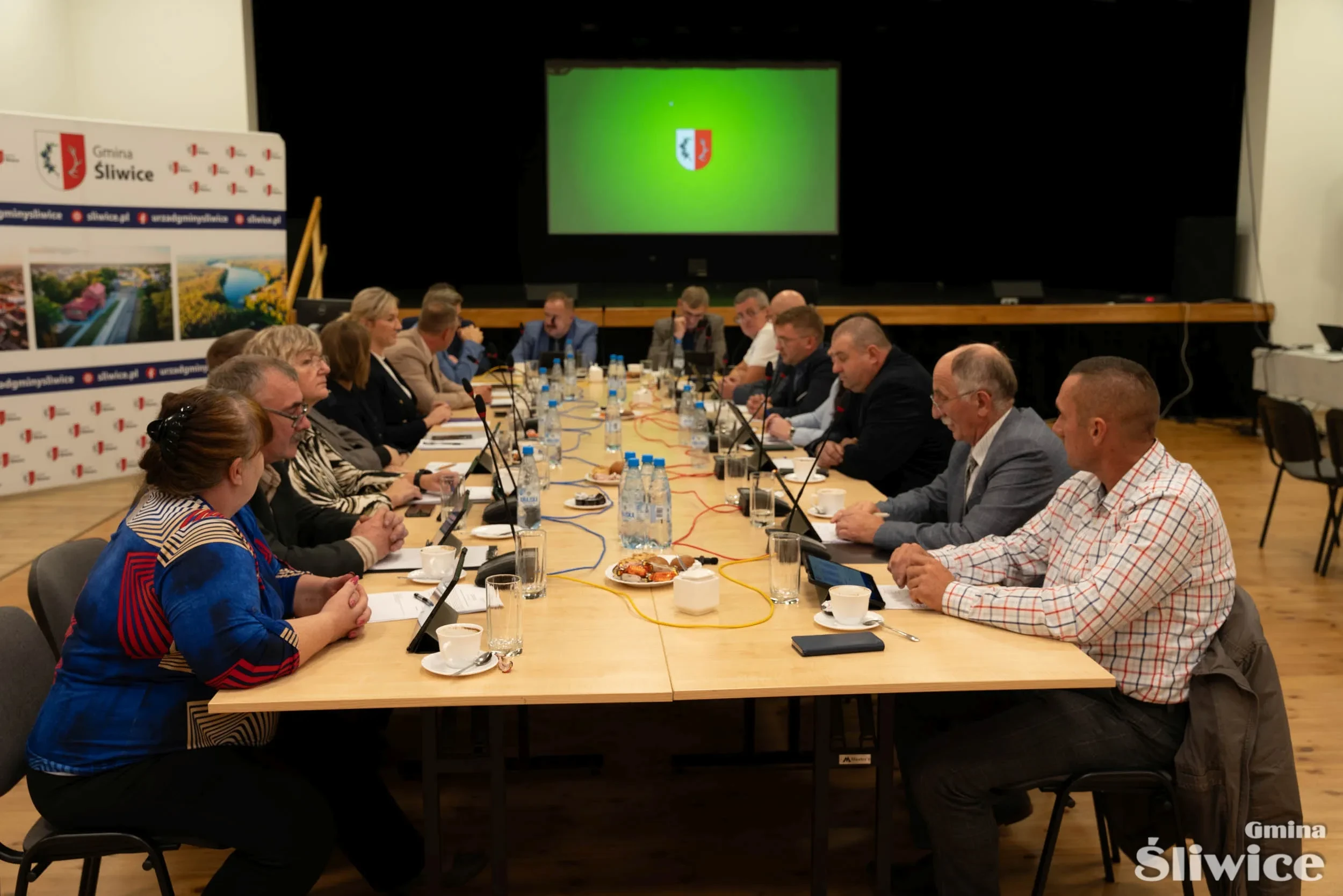 radni zebrani przy stole na początku sesji