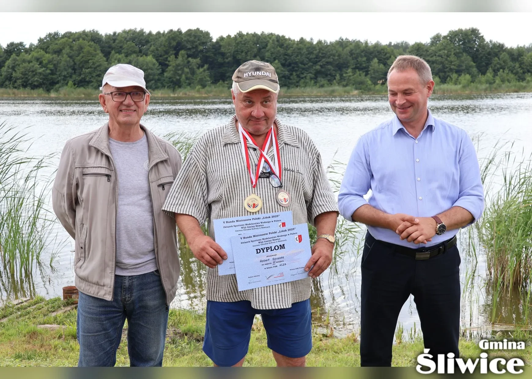 mężczyzna z dwoma medalami i dwoma dyplomami