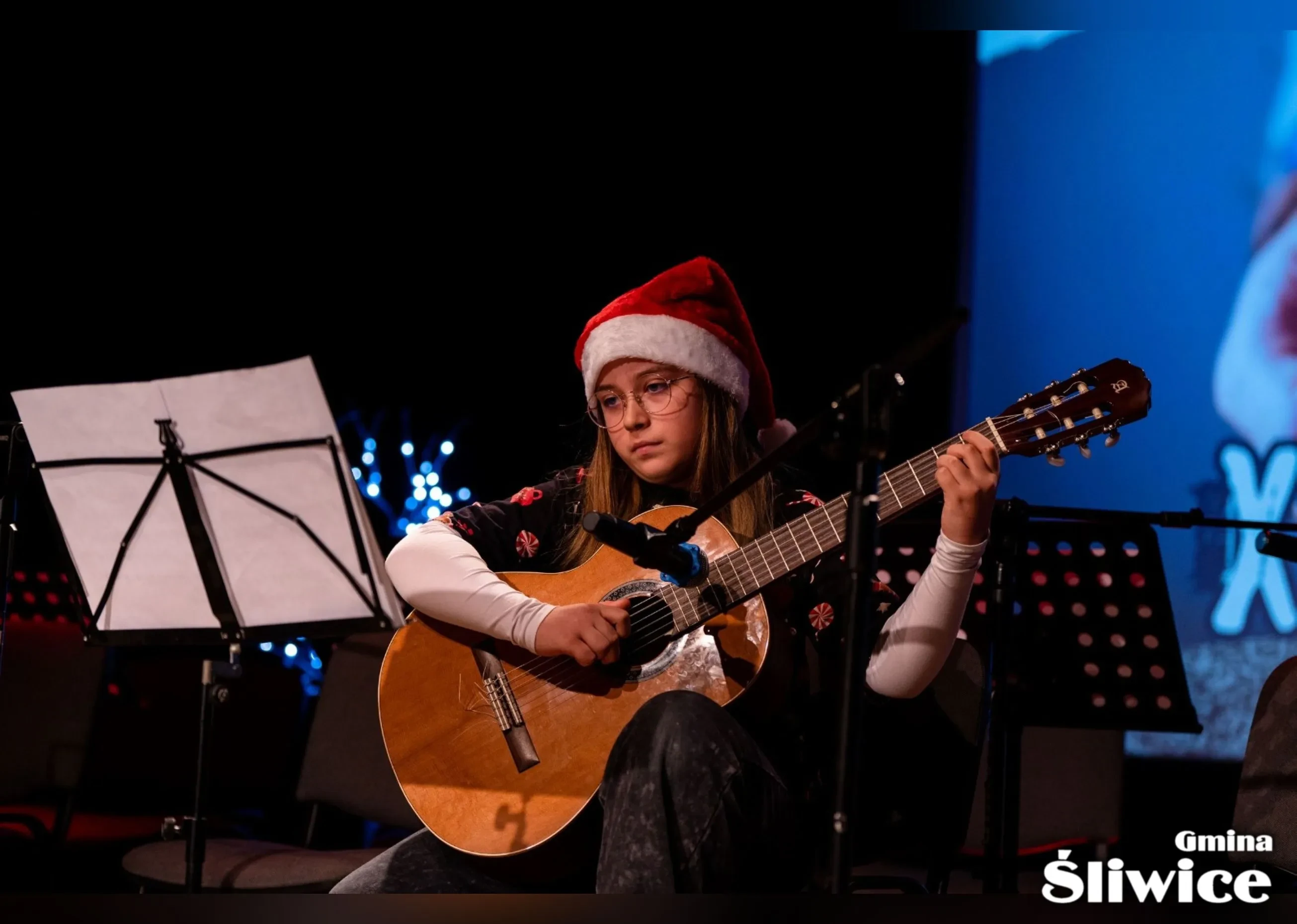 dziewczynka prezentuje swój utwór na gitarze