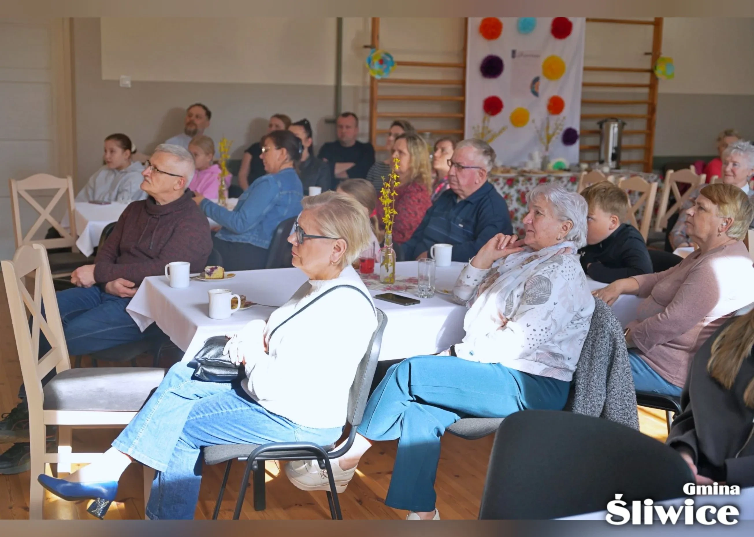 zebrani siedzą przy stołach